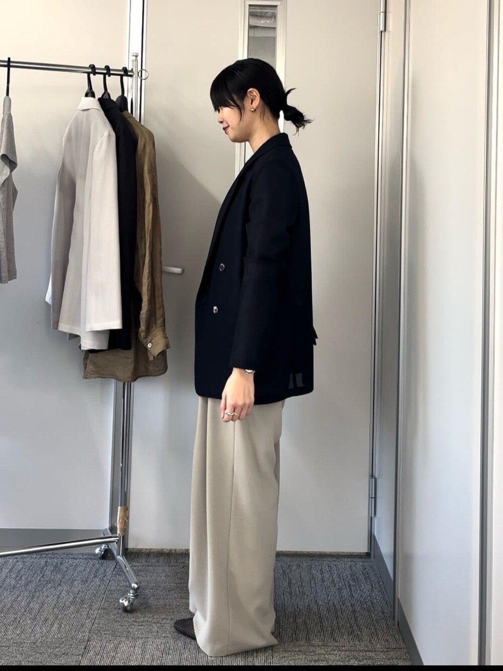 ブルー系のテーラードジャケット、グレー系のスラックスを着用したレディースの春コーディネートの3枚目の写真