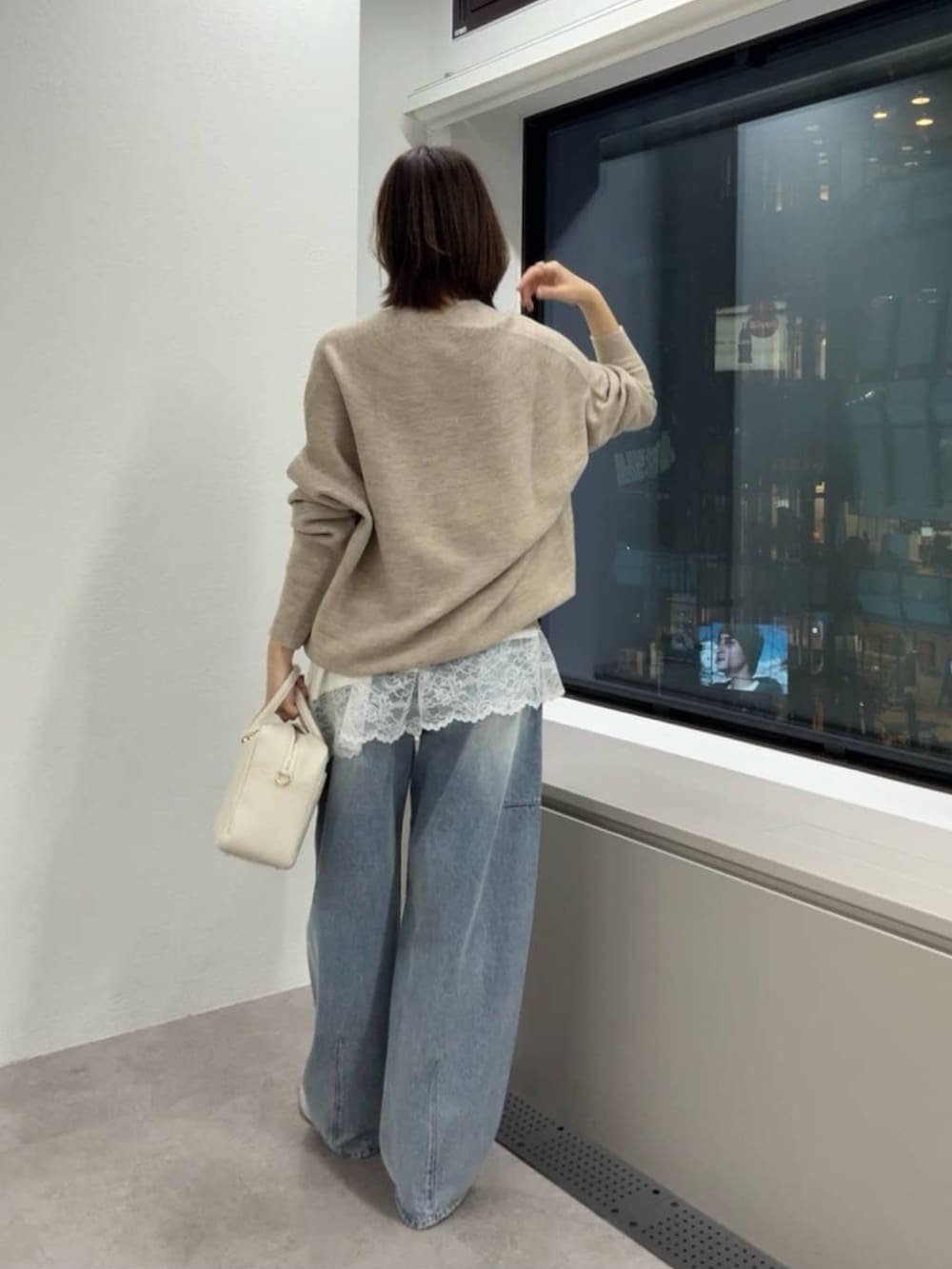 ベージュ系のニット/セーター、ホワイト系のキャミソール、ホワイト系のボストンバッグを着用したレディースの冬コーディネートの3枚目の写真