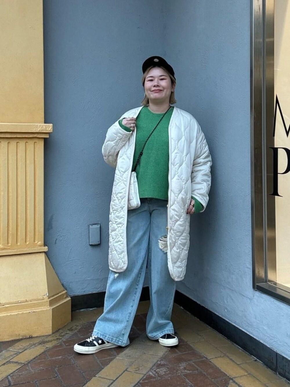 ブルー系のデニムパンツ、グリーン系のニット/セーターを着用したレディースの冬コーディネートの2枚目の写真