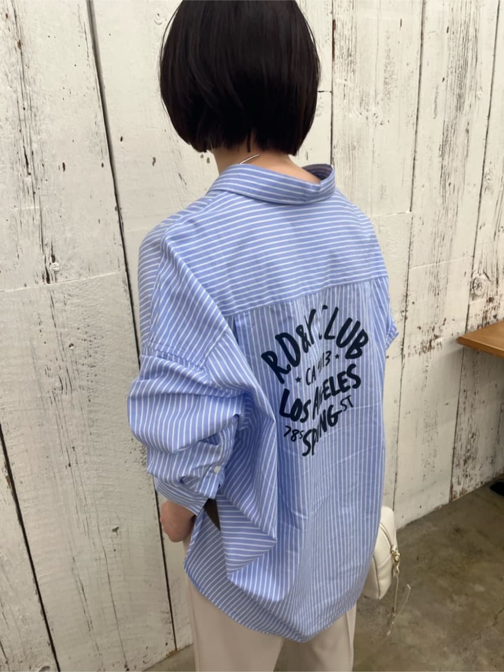 ホワイト系のボストンバッグ、ブルー系のシャツ/ブラウス、グリーン系のその他アウターを着用したレディースの春コーディネートの9枚目の写真