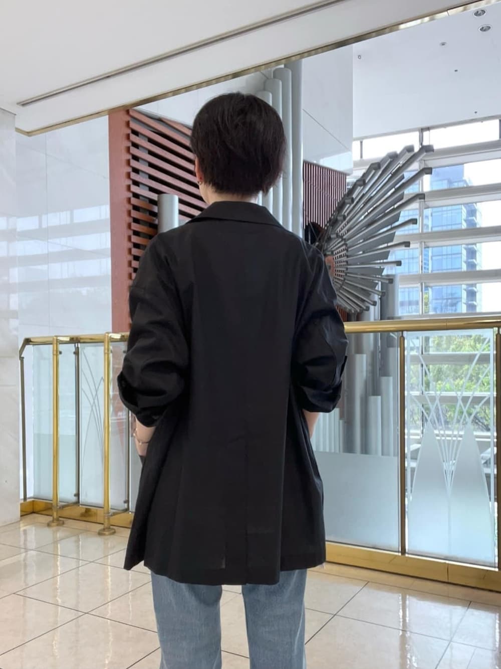 グリーン系のテーラードジャケット、ホワイト系のシャツ/ブラウス、ブラック系のサンダルを着用したレディースの春コーディネートの3枚目の写真