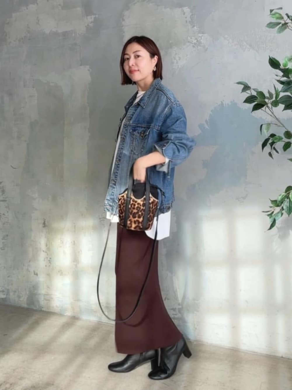 ブルー系のデニムジャケット、ホワイト系のTシャツ/カットソー、ブラック系のブーツを着用したレディースの冬コーディネートの2枚目の写真