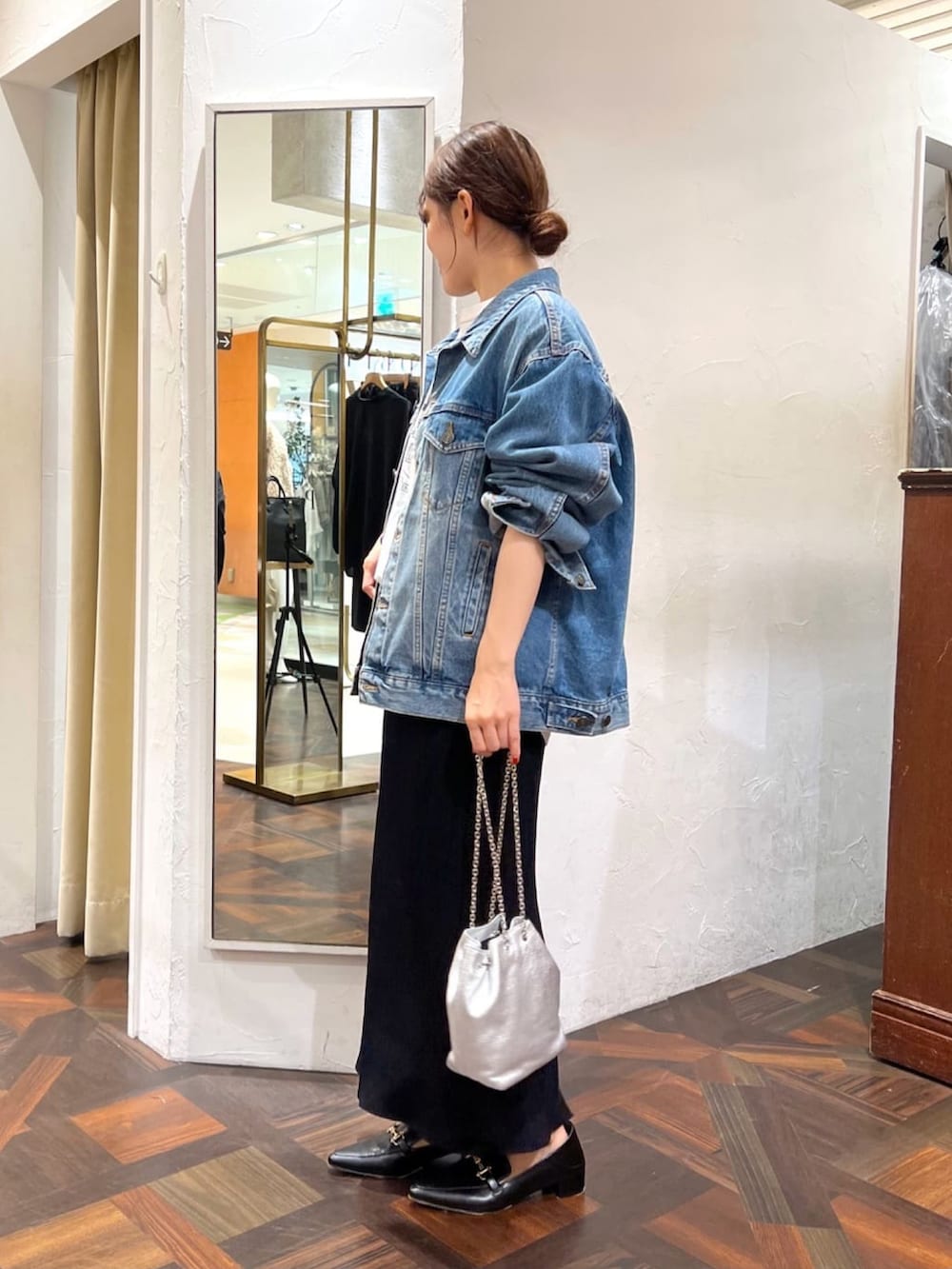 シルバー系のショルダーバッグ、ブラック系のスカート、ブラック系のローファーを着用したレディースの秋コーディネートの3枚目の写真