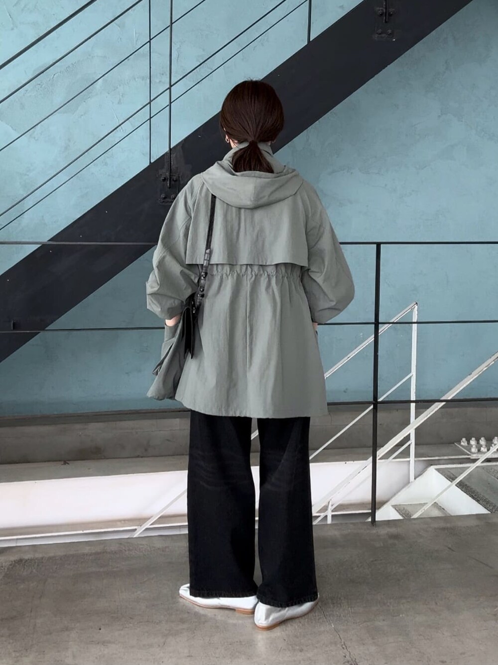 グリーン系のマウンテンパーカー、ブラック系のデニムパンツを着用したレディースの夏コーディネートの5枚目の写真