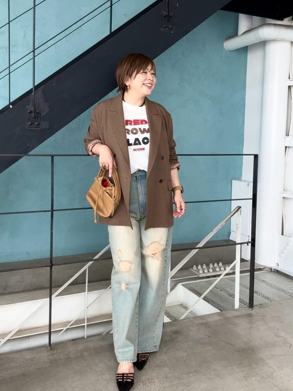 ブルー系のデニムパンツ、イエロー系のハンドバッグ、ホワイト系のTシャツ/カットソーを着用したレディースの夏コーディネートの2枚目の写真