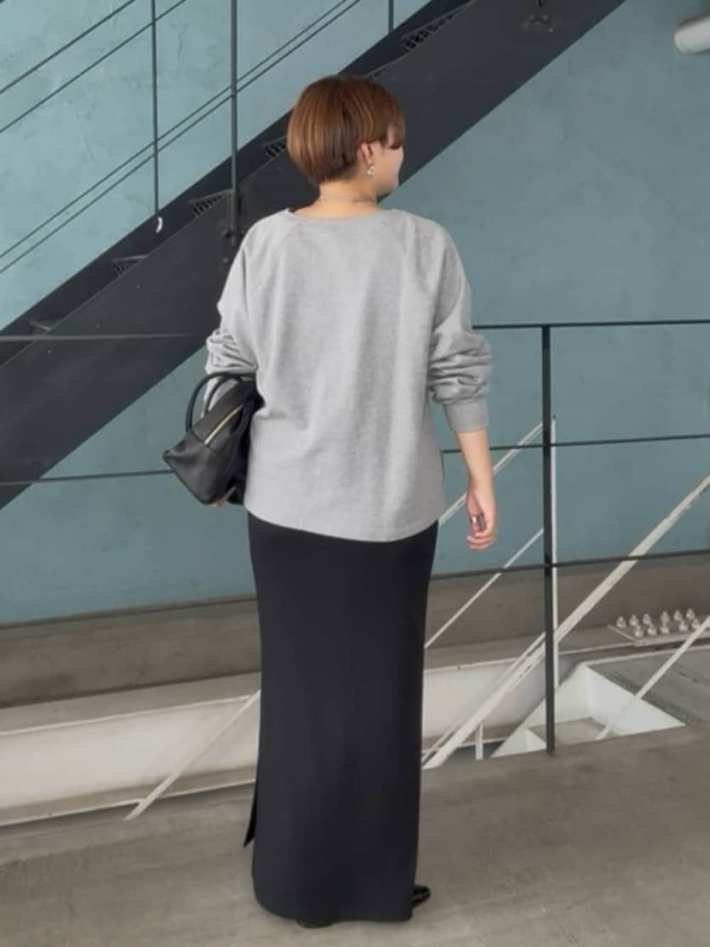 グレー系のスウェット、ブラック系のワンピース、シルバー系のチョーカーを着用したレディースの春コーディネートの4枚目の写真