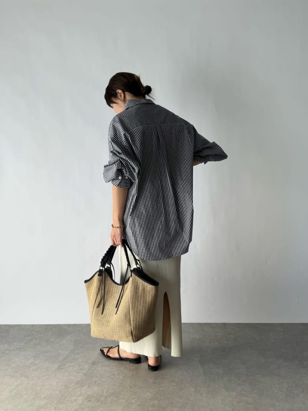 ブラック系のシャツ/ブラウス、ホワイト系のスカート、ブラック系のショルダーバッグを着用したレディースの春コーディネートの2枚目の写真