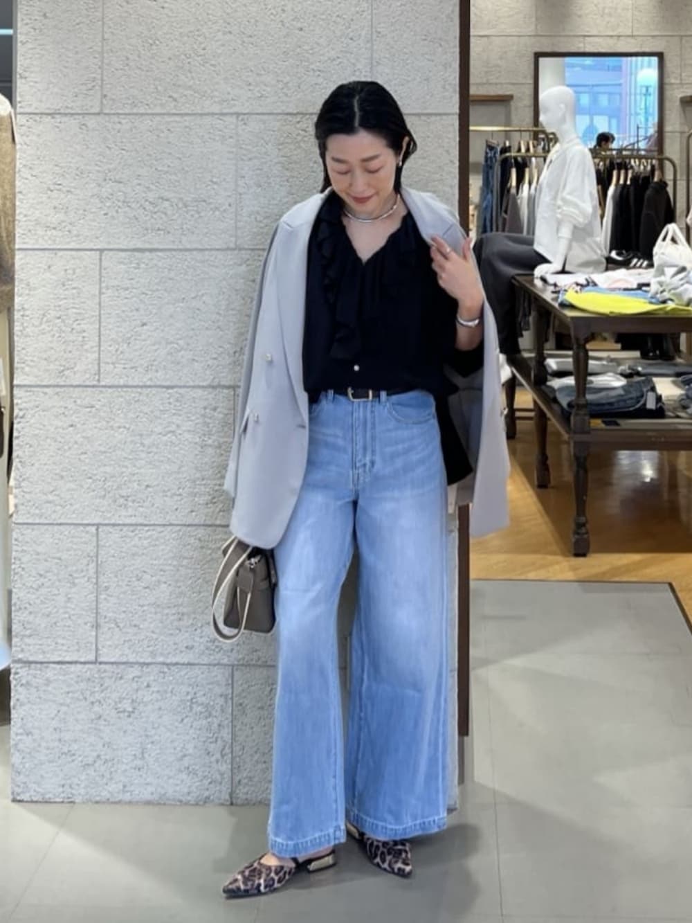 グレー系のトートバッグ、ブラック系のシャツ/ブラウス、ブルー系のデニムパンツを着用したレディースの春コーディネートの5枚目の写真