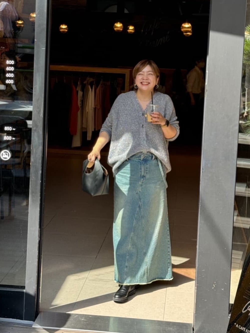 グレー系のカーディガン/ボレロ、ブルー系のデニムスカートを着用したレディースの秋コーディネートの2枚目の写真