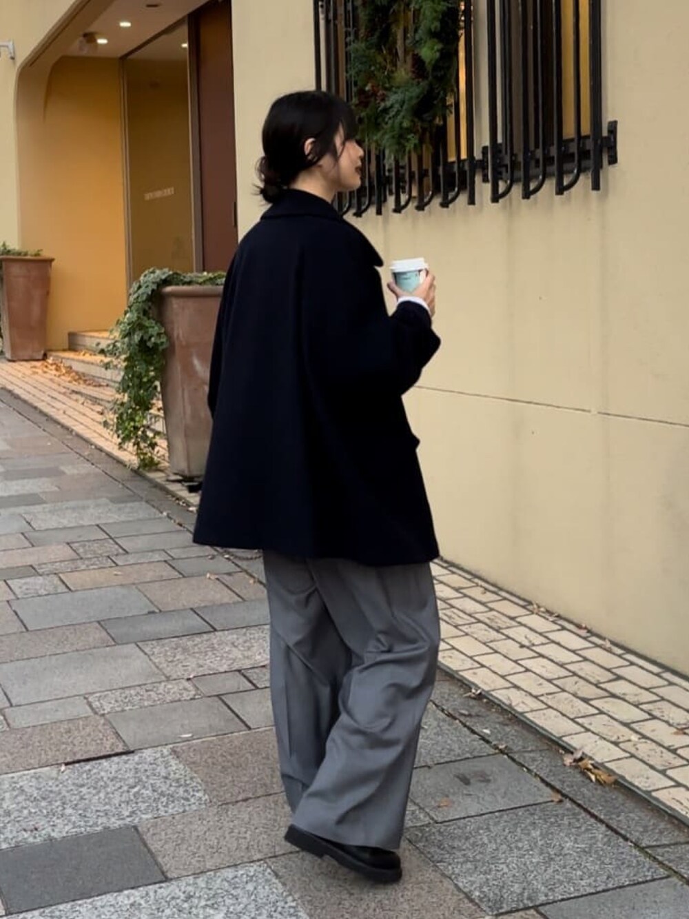 ブルー系のピーコート、グレー系のその他パンツ、ブラック系のブーツを着用したレディースの冬コーディネートの2枚目の写真