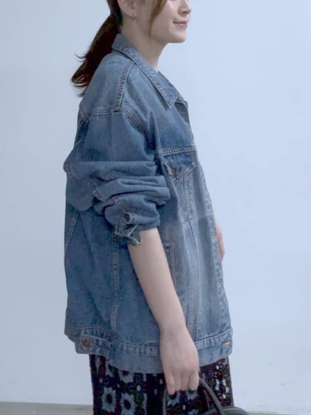 ブルー系のデニムジャケット、ブラック系のその他シューズ、ブラック系のボストンバッグを着用したレディースの冬コーディネートの4枚目の写真