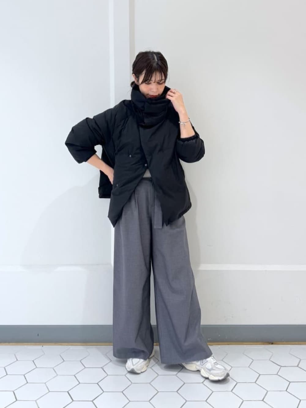 ブラック系のダウンジャケット/コート、グレー系のニット/セーター、グレー系のその他パンツを着用したレディースの冬コーディネートの2枚目の写真