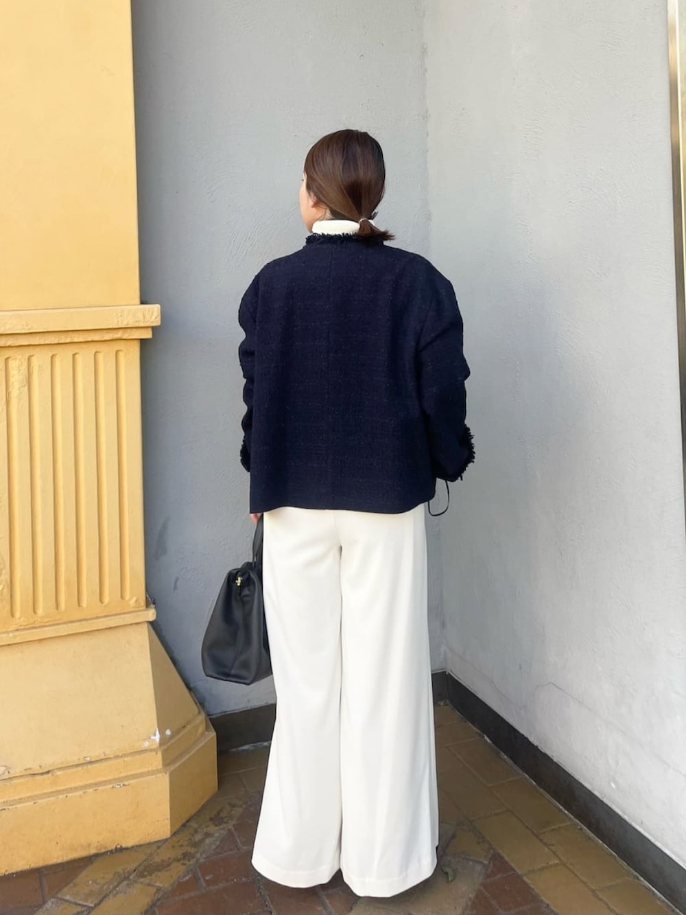 ブルー系のノーカラージャケット、ホワイト系のスラックス、ホワイト系のニット/セーターを着用したレディースの冬コーディネートの3枚目の写真