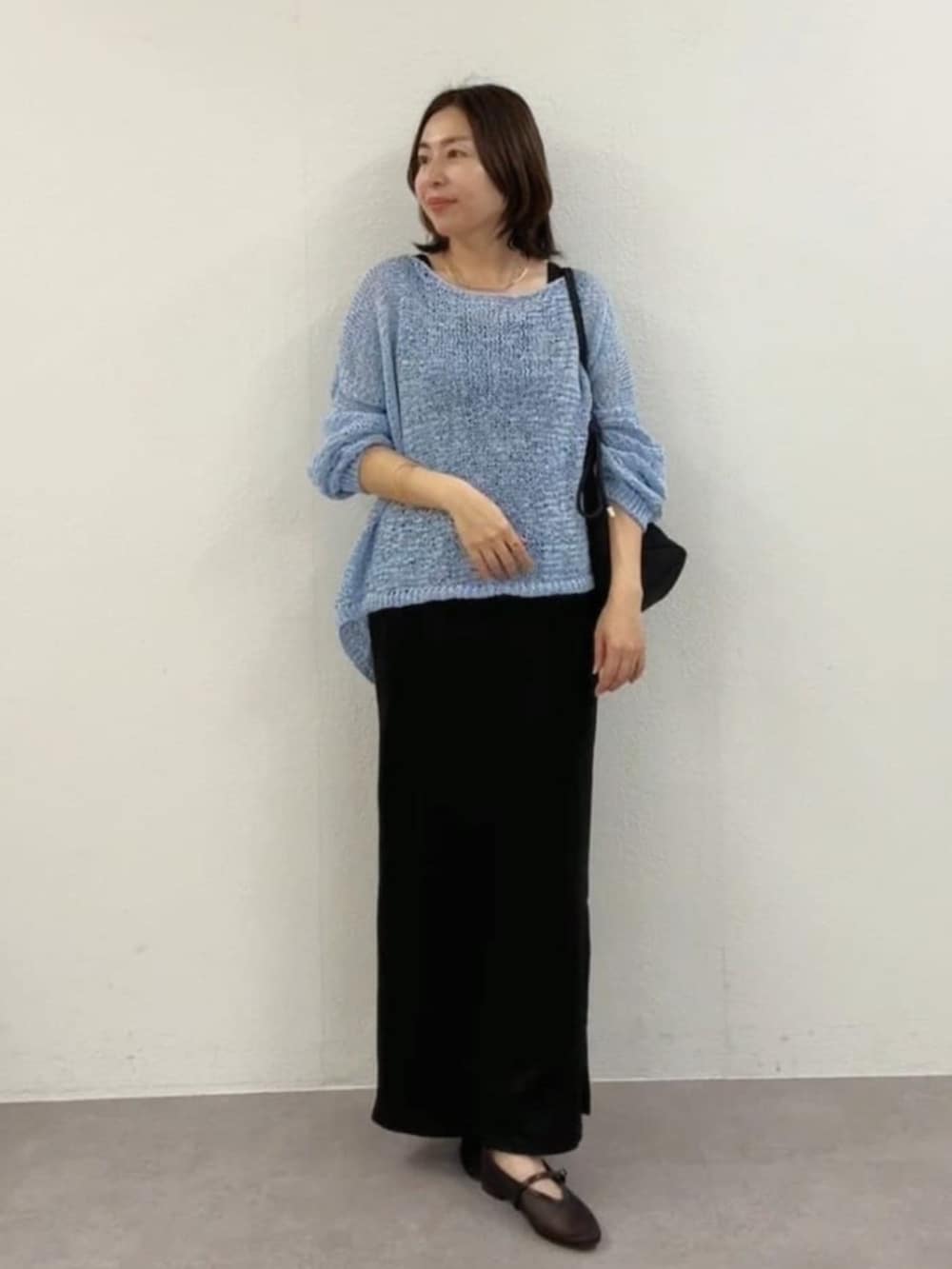 ブラック系のその他シューズ、ブルー系のニット/セーター、ブラック系のワンピースを着用したレディースの春コーディネートの4枚目の写真