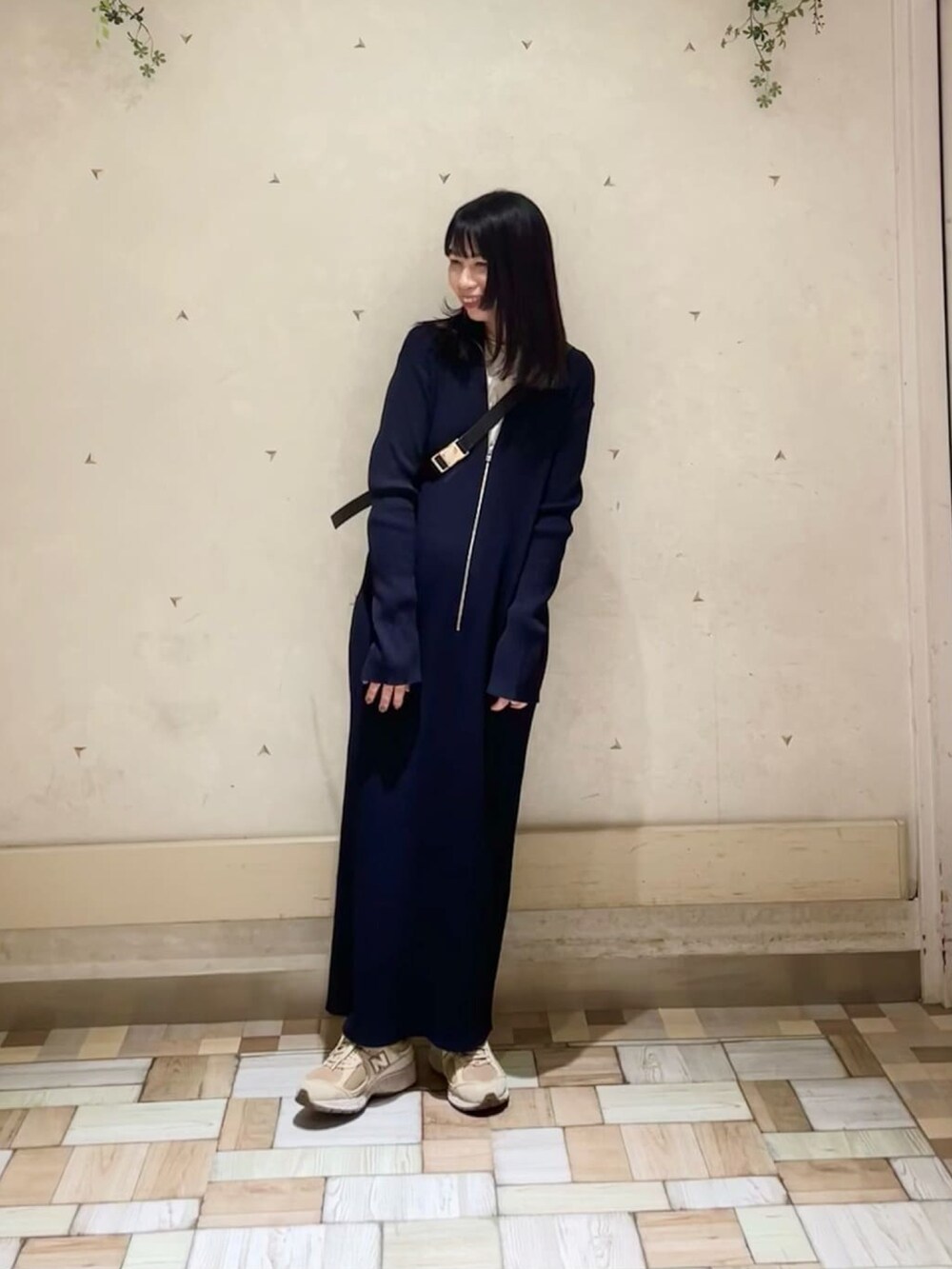 ブラック系のボディバッグ/ウエストポーチ、ブルー系のワンピース、ホワイト系のTシャツ/カットソーを着用したレディースの春コーディネートの2枚目の写真