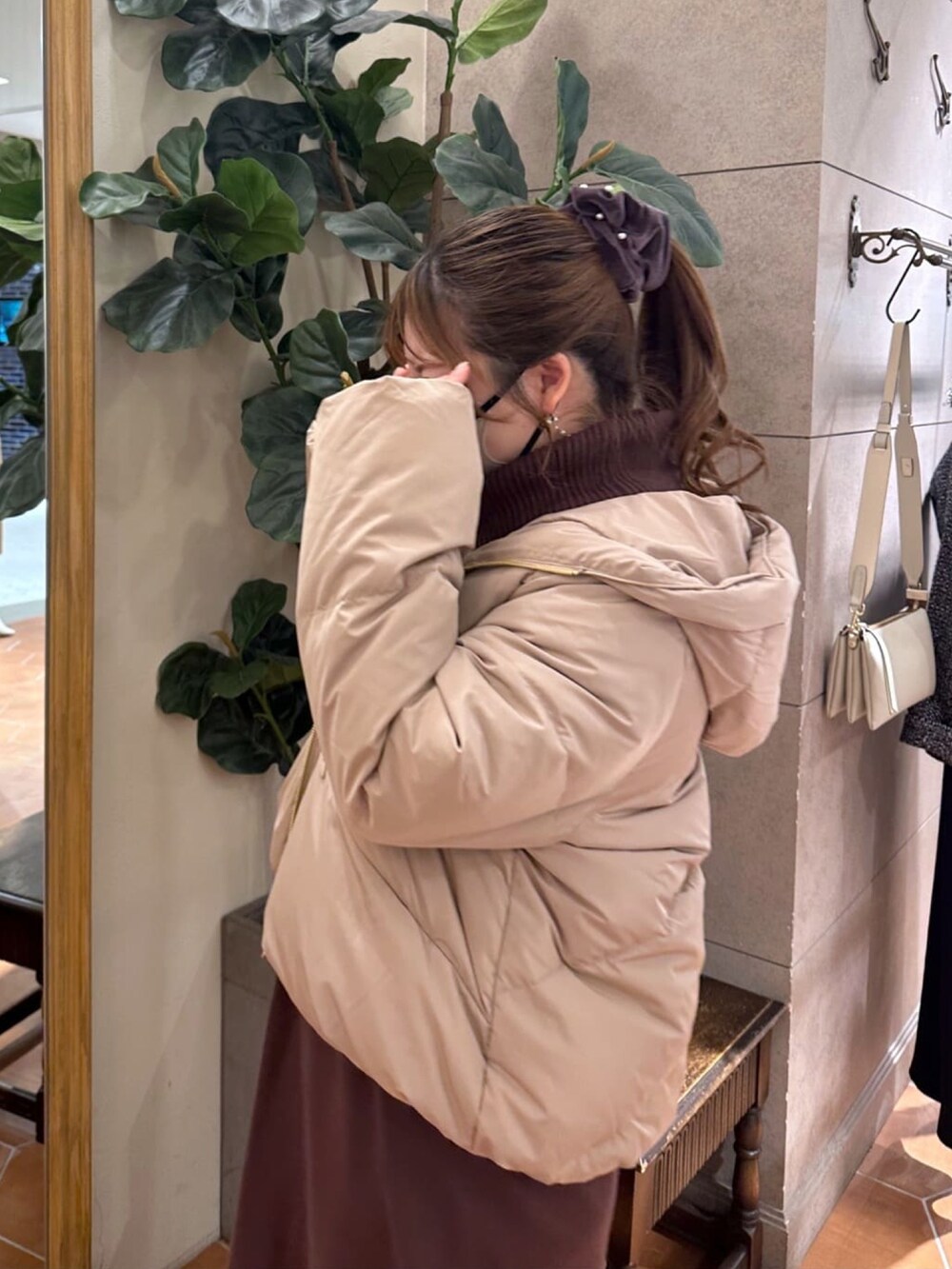 ブラウン系のワンピース、ブラック系のブーツ、ブラック系のダウンジャケット/コートを着用したレディースの冬コーディネートの5枚目の写真