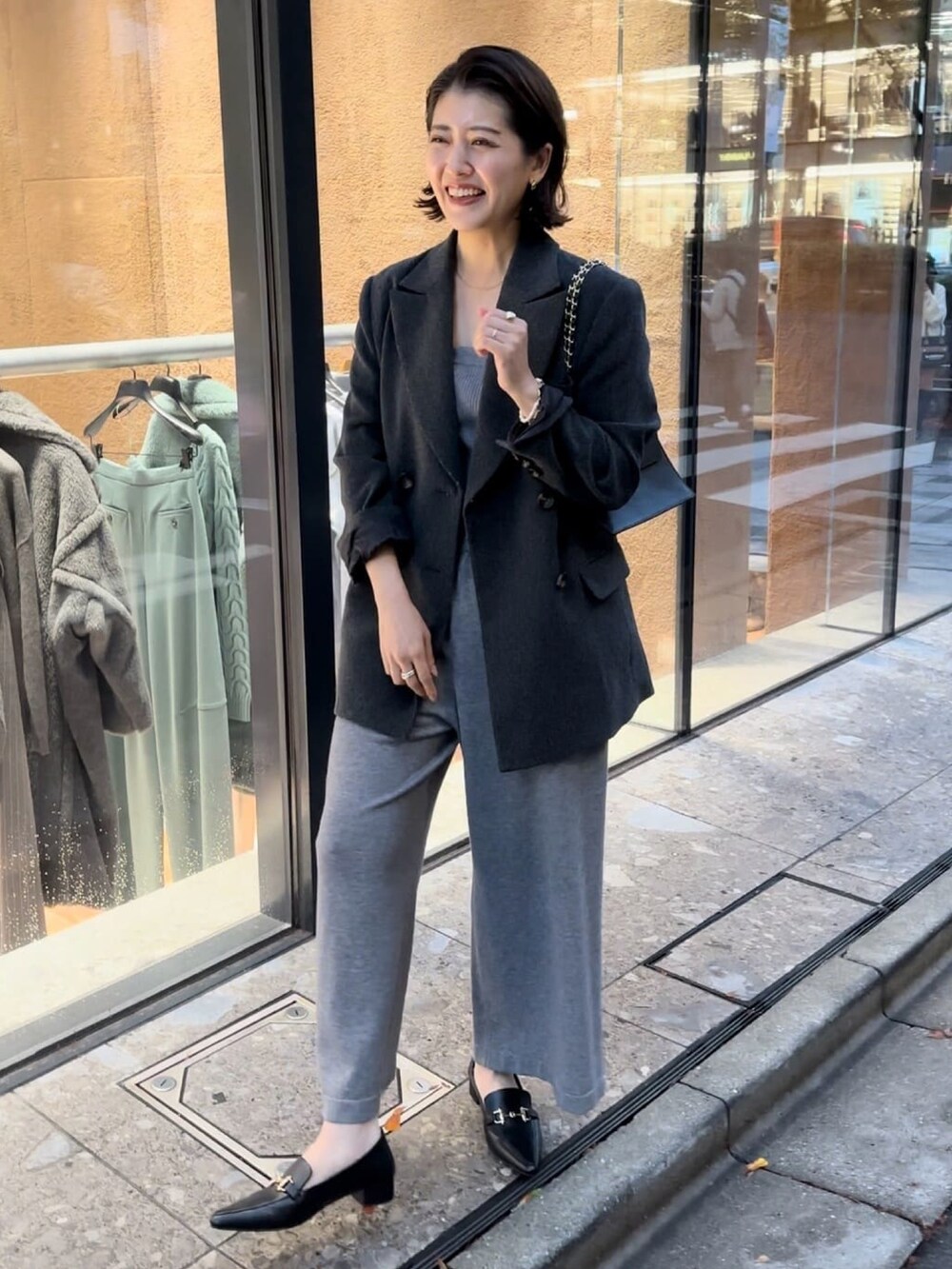 グレー系のその他アウター、グレー系のサロペット/オーバーオール、ブラック系のローファーを着用したレディースの冬コーディネートの3枚目の写真