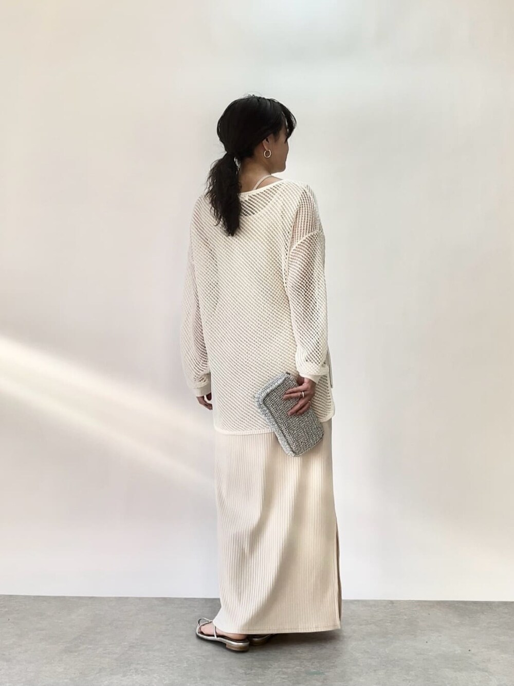 ホワイト系のワンピース、オレンジ系のニット/セーターを着用したレディースの春コーディネートの3枚目の写真