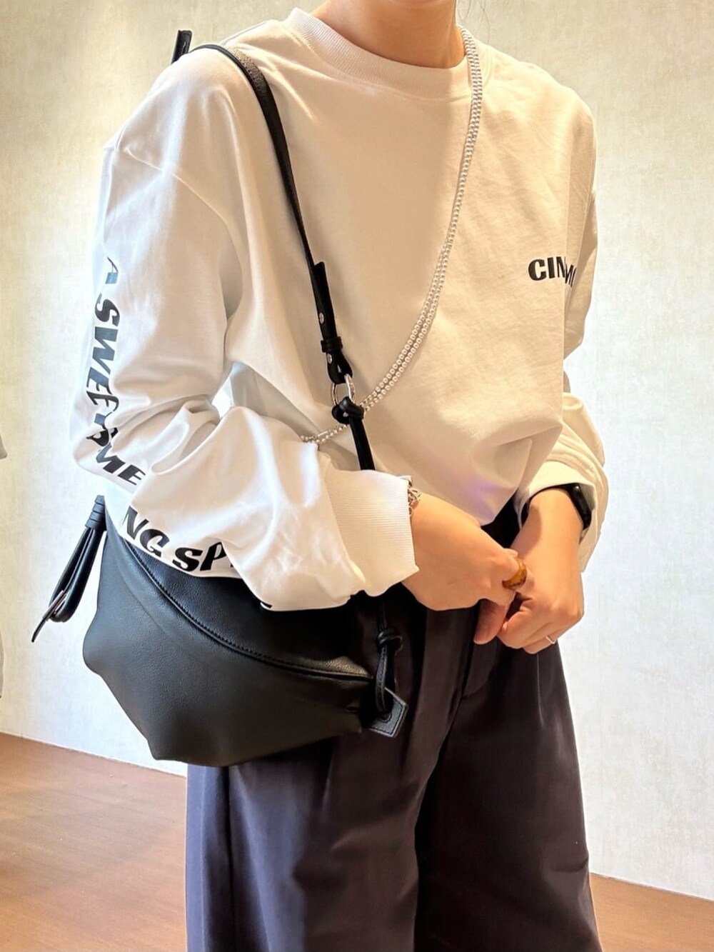 ホワイト系のTシャツ/カットソー、ブルー系のチノパンツ、ブラック系のローファーを着用したレディースの冬コーディネートの5枚目の写真