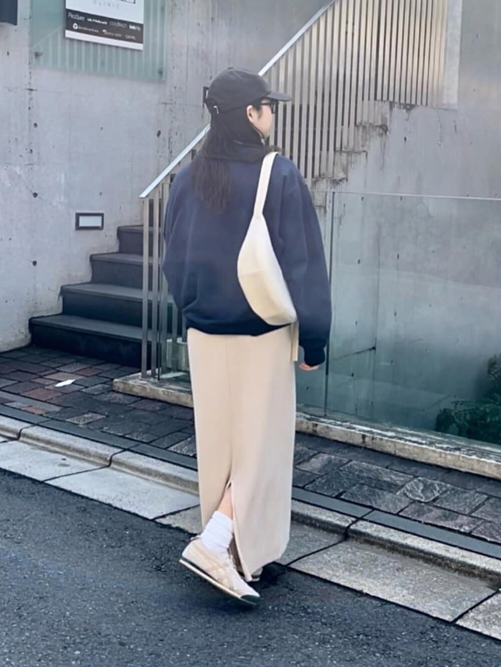 ホワイト系のワンピース、ブルー系のスウェット、ブラック系のキャップを着用したレディースの冬コーディネートの3枚目の写真