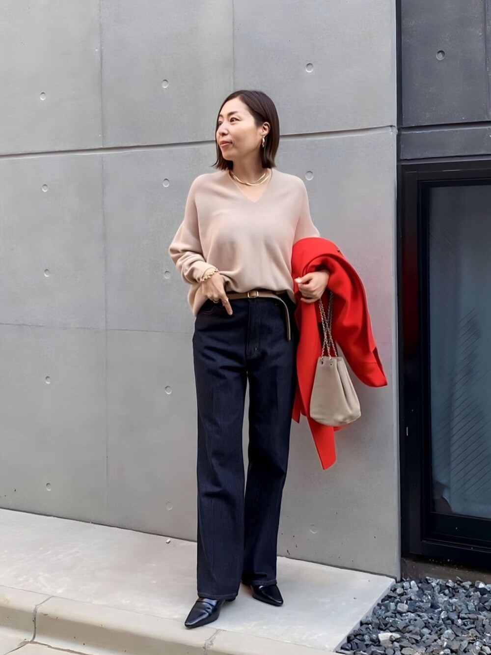ブルー系のデニムパンツ、ブラック系のローファー、ベージュ系のショルダーバッグを着用したレディースの冬コーディネートの4枚目の写真