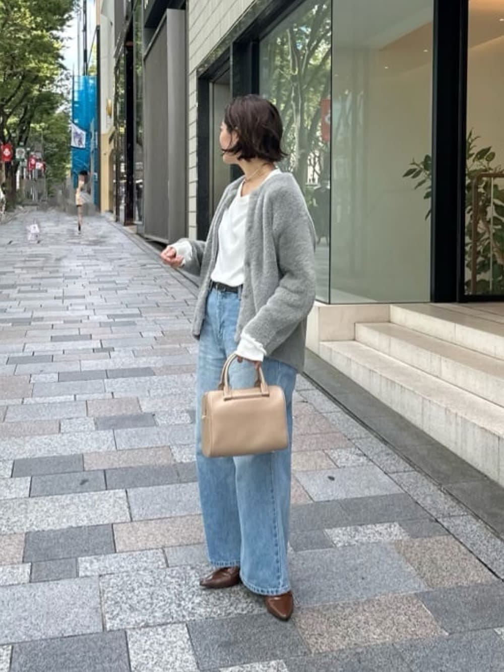 グレー系のカーディガン/ボレロ、ブルー系のデニムパンツ、ホワイト系のTシャツ/カットソーを着用したレディースの秋コーディネートの3枚目の写真