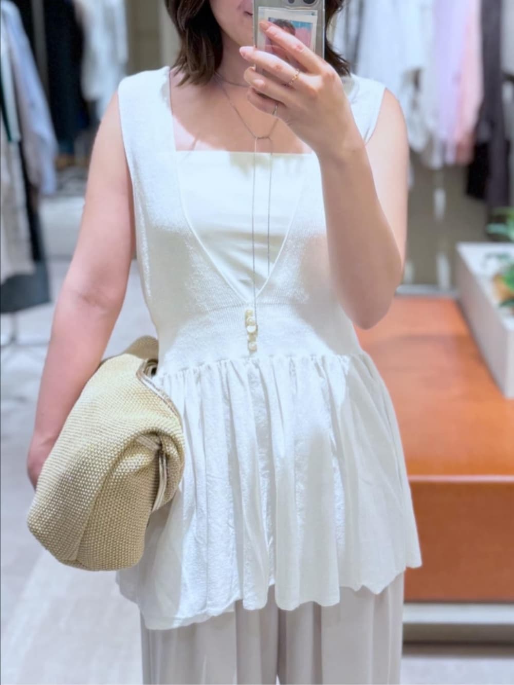 ベージュ系のスラックス、ベージュ系のサンダル、ホワイト系のニット/セーターを着用したレディースの夏コーディネートの2枚目の写真