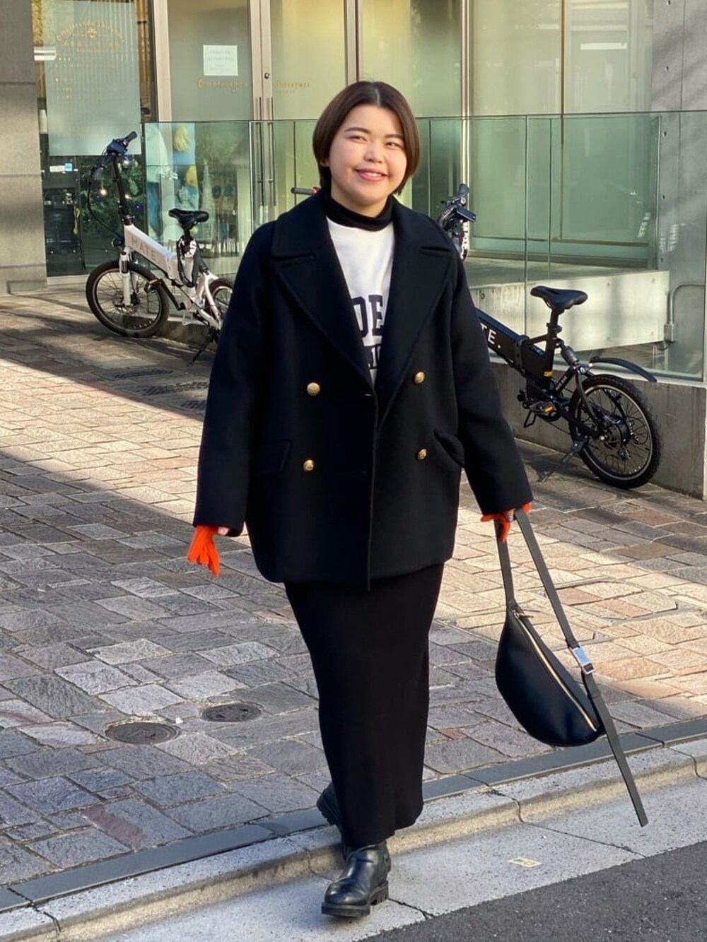 ホワイト系のスウェット、ブラック系のスカート、ブラック系のブーツを着用したレディースの冬コーディネートの2枚目の写真