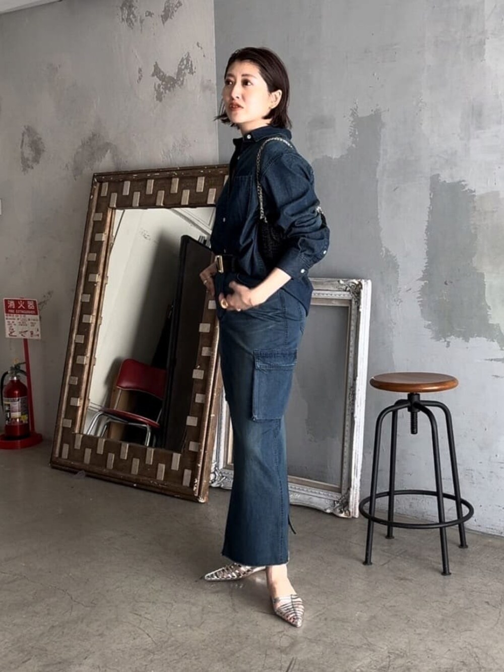 ブルー系のデニムスカート、ブラック系のショルダーバッグ、ブルー系のシャツ/ブラウスを着用したレディースの春コーディネートの3枚目の写真