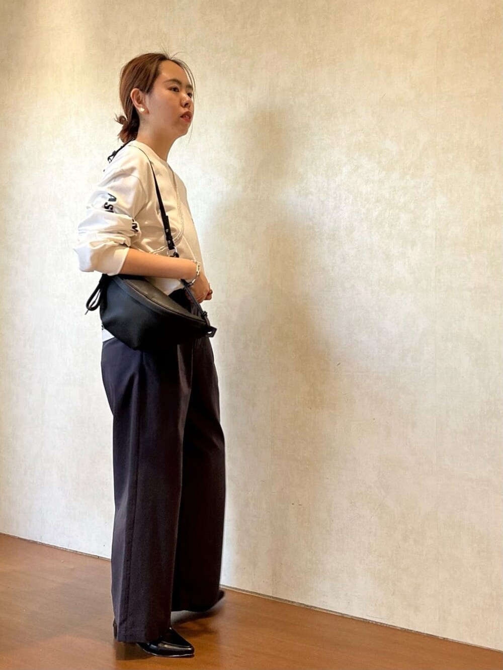 ホワイト系のTシャツ/カットソー、ブルー系のチノパンツ、ブラック系のローファーを着用したレディースの冬コーディネートの2枚目の写真