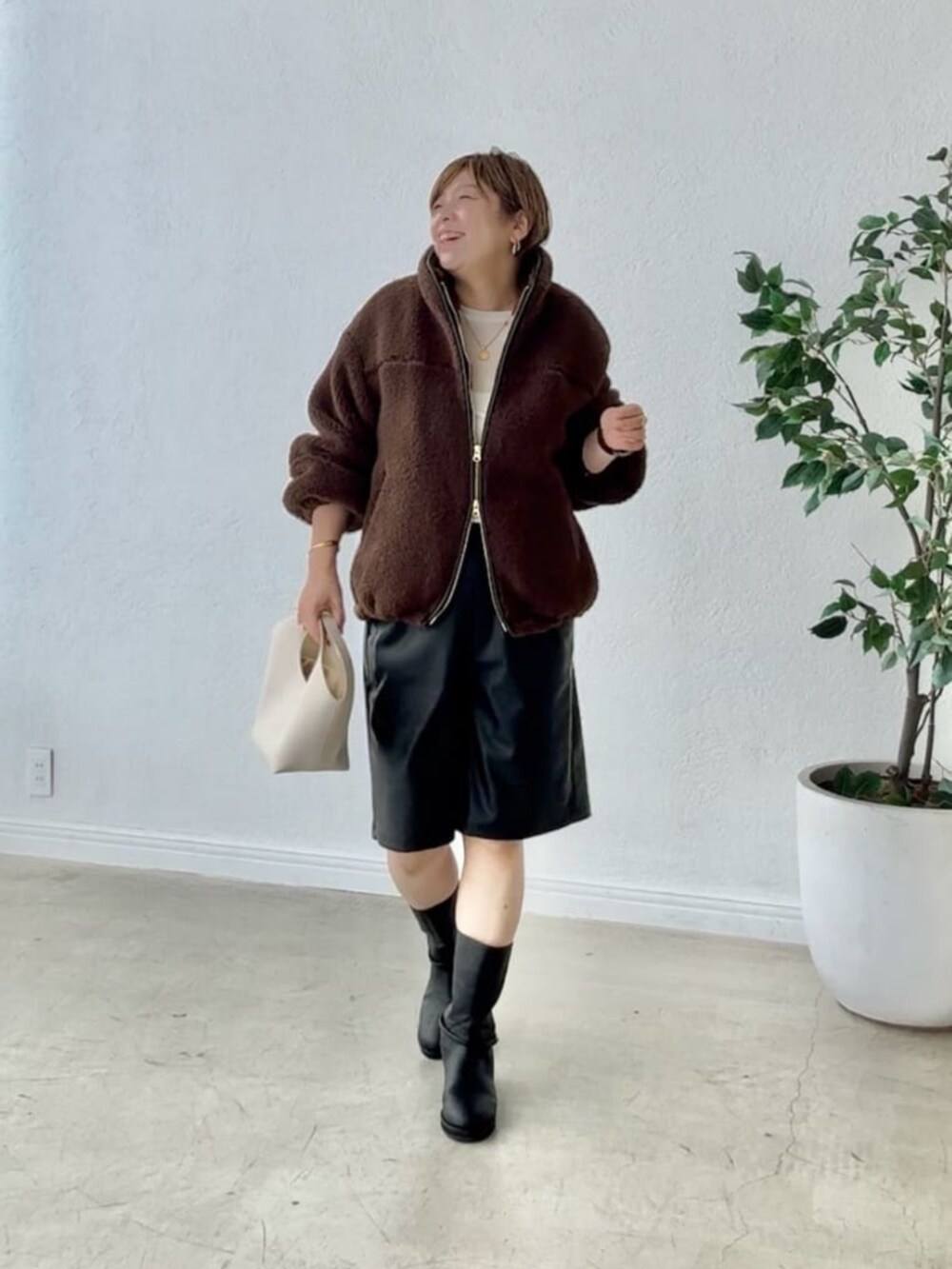 ブラック系のブーツ、ブラック系のその他パンツ、ホワイト系のTシャツ/カットソーを着用したレディースの秋コーディネートの2枚目の写真