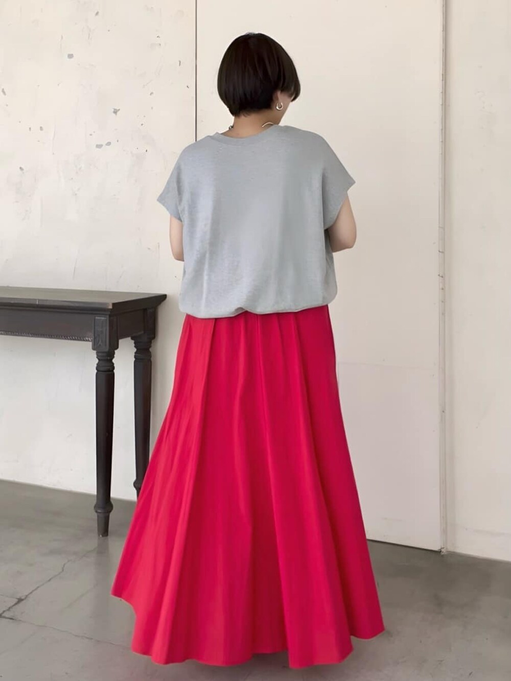 グレー系のTシャツ/カットソー、ブラック系のショルダーバッグ、レッド系のスカートを着用したレディースの夏コーディネートの3枚目の写真