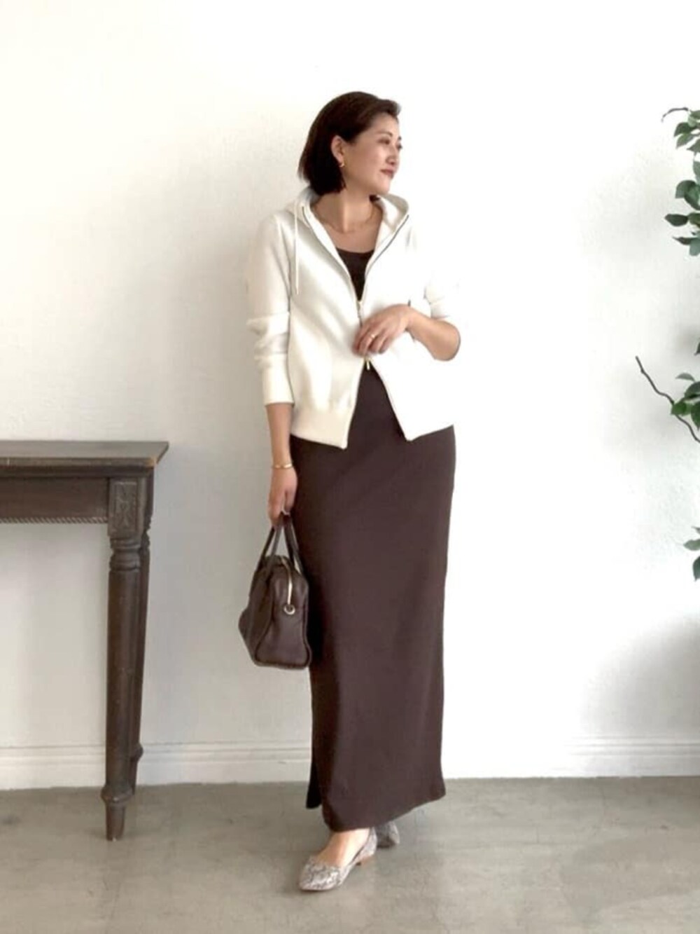 ホワイト系のパーカー、グレー系のパンプス、ブラウン系のワンピースを着用したレディースの冬コーディネートの5枚目の写真