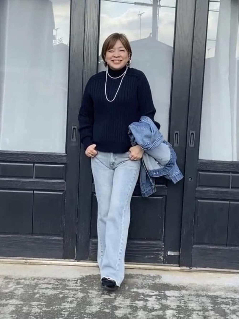 ブルー系のニット/セーター、ブルー系のデニムジャケット、ブルー系のデニムパンツを着用したレディースの冬コーディネートの3枚目の写真