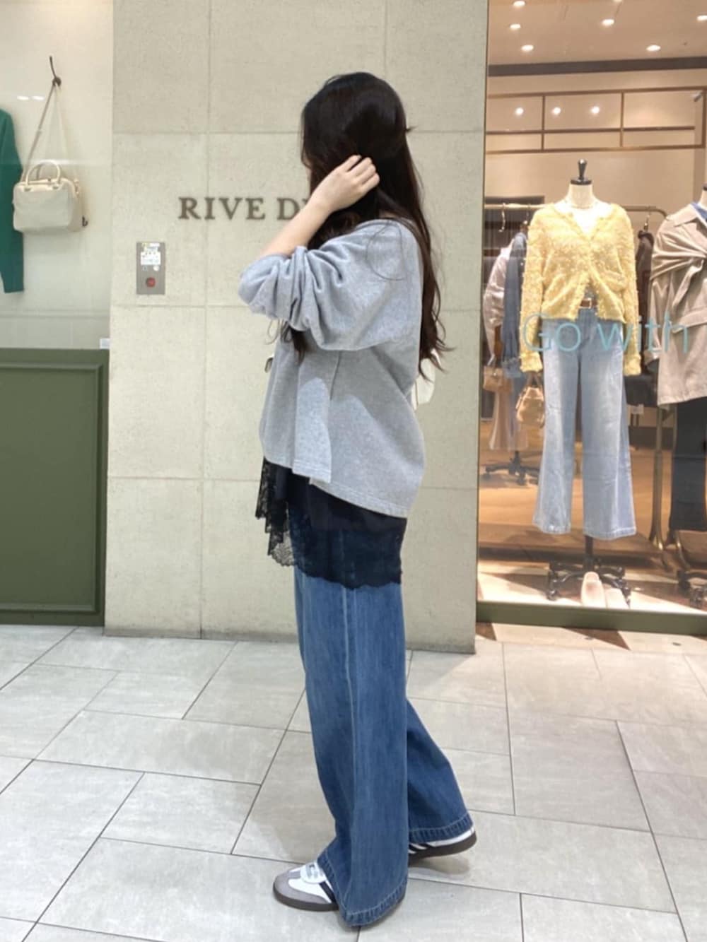 グレー系のスウェット、ブラウン系のキャミソール、ホワイト系のショルダーバッグを着用したレディースの春コーディネートの2枚目の写真