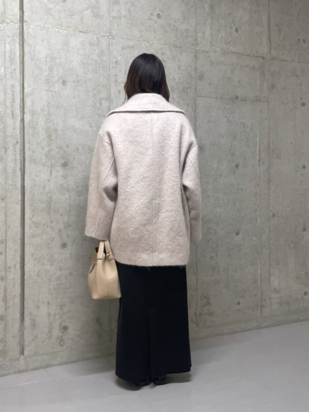 ベージュ系のその他アウター、ホワイト系のトートバッグ、ブラック系のスカートを着用したレディースの冬コーディネートの3枚目の写真