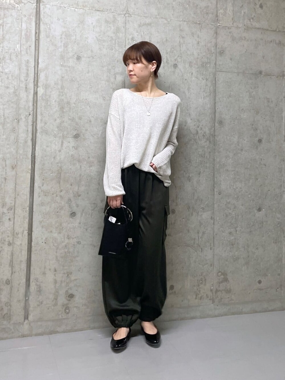 ホワイト系のパーカー、グリーン系のカーゴパンツ、グレー系のニット/セーターを着用したレディースの冬コーディネートの2枚目の写真