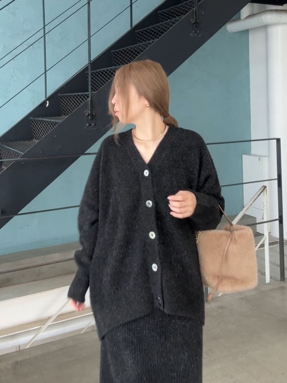 ブラック系のカーディガン/ボレロ、ブラック系のスカート、ベージュ系のハンドバッグを着用したレディースの秋コーディネートの5枚目の写真