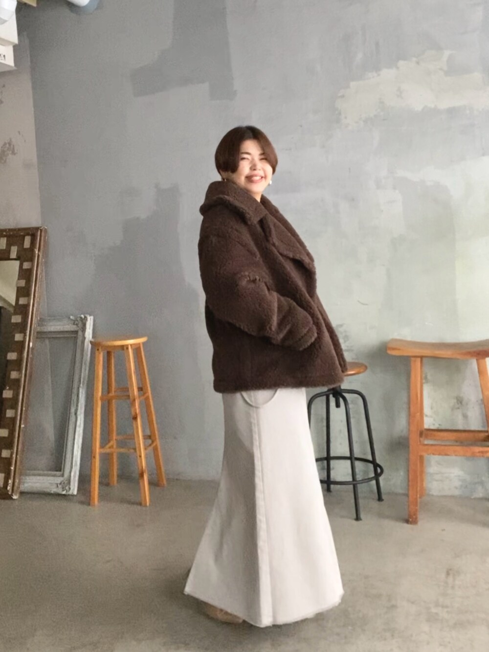 ベージュ系のブーツ、ホワイト系のニット/セーター、ブラウン系のその他アウターを着用したレディースの秋コーディネートの2枚目の写真