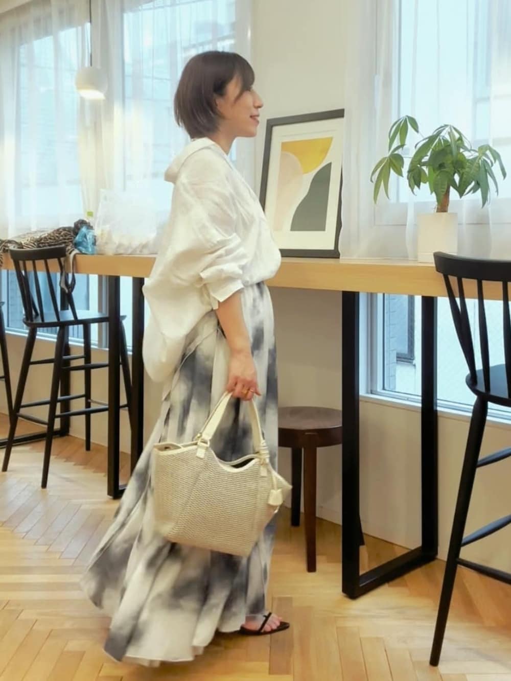 ホワイト系のシャツ/ブラウス、ブラック系のサンダル、ホワイト系のハンドバッグを着用したレディースの春コーディネートの4枚目の写真