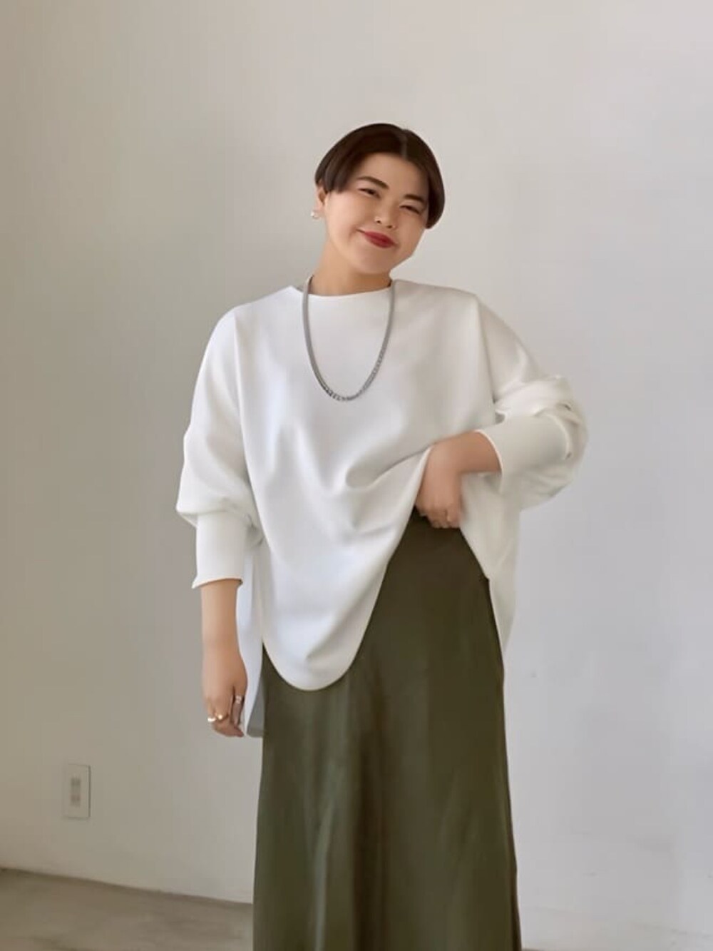 ホワイト系のTシャツ/カットソー、グリーン系のスカート、ブラック系のショルダーバッグを着用したレディースの春コーディネートの3枚目の写真