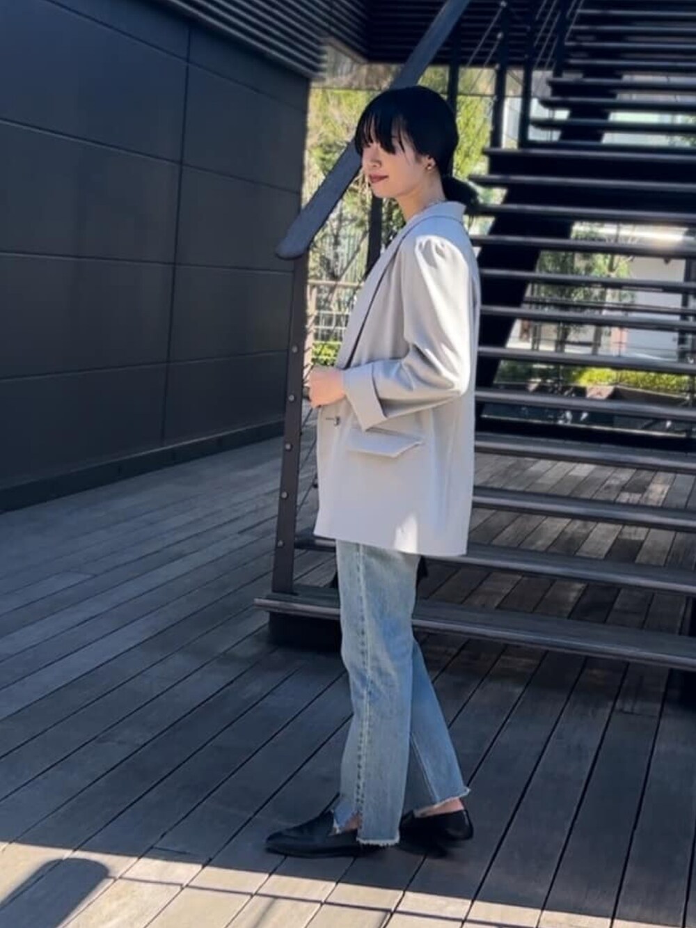 ホワイト系のTシャツ/カットソー、グレー系のテーラードジャケット、ブルー系のデニムパンツを着用したレディースの冬コーディネートの2枚目の写真