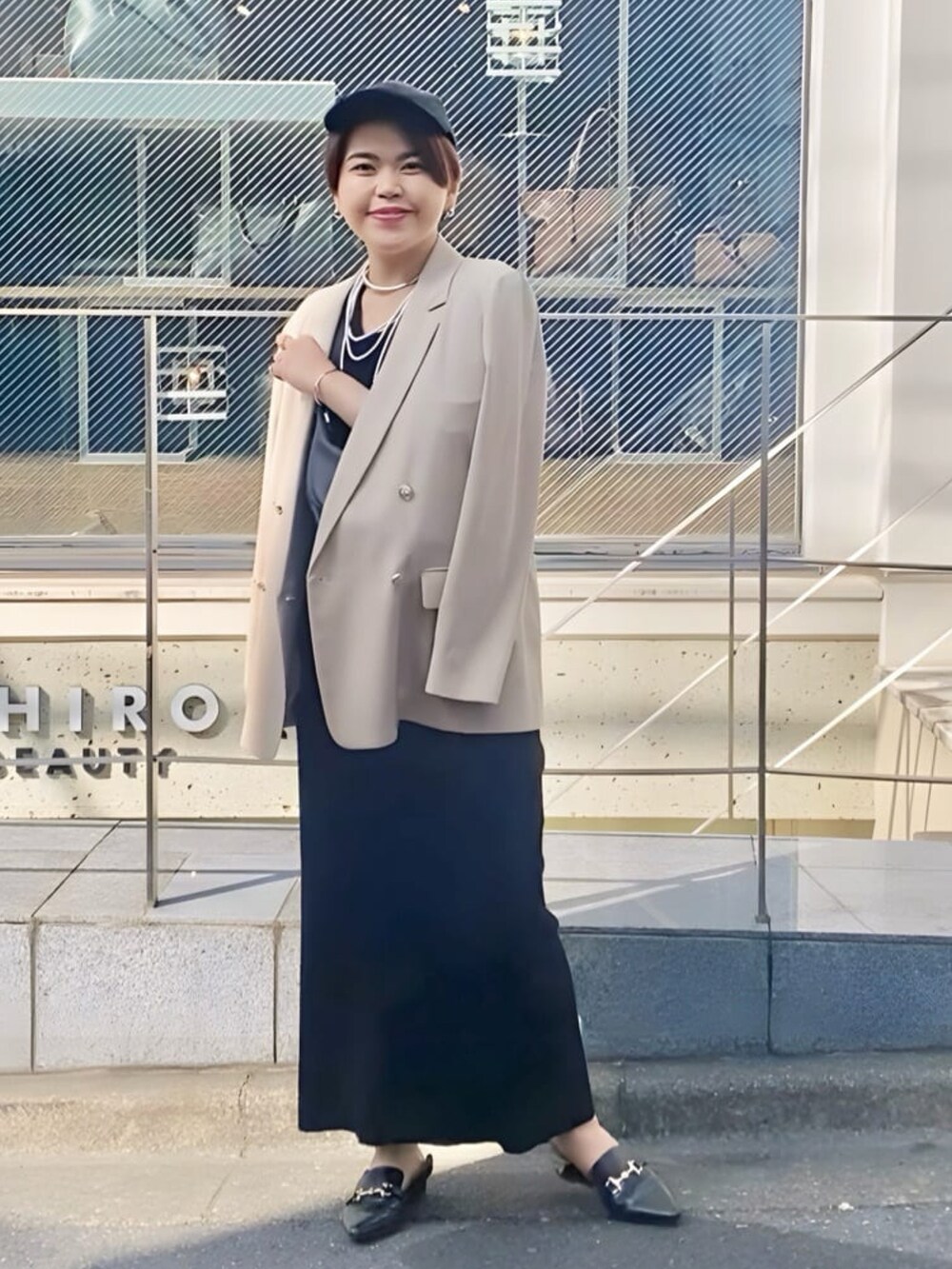 ベージュ系のテーラードジャケット、ブラック系のワンピース、ブラック系のローファーを着用したレディースの冬コーディネートの2枚目の写真