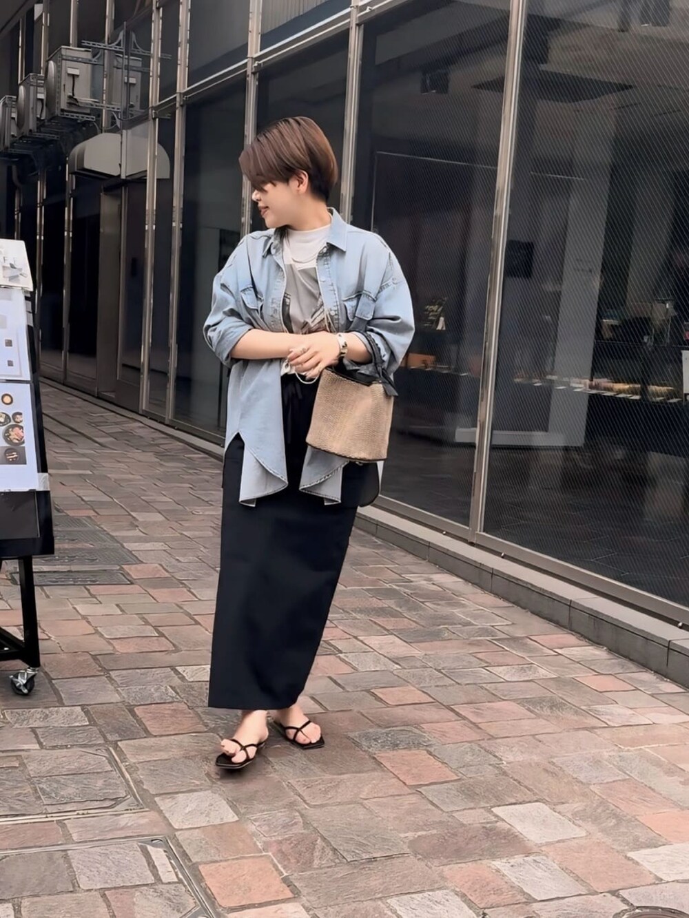 グレー系のTシャツ/カットソー、ブルー系のシャツ/ブラウス、ブラック系のスカートを着用したレディースの春コーディネートの4枚目の写真