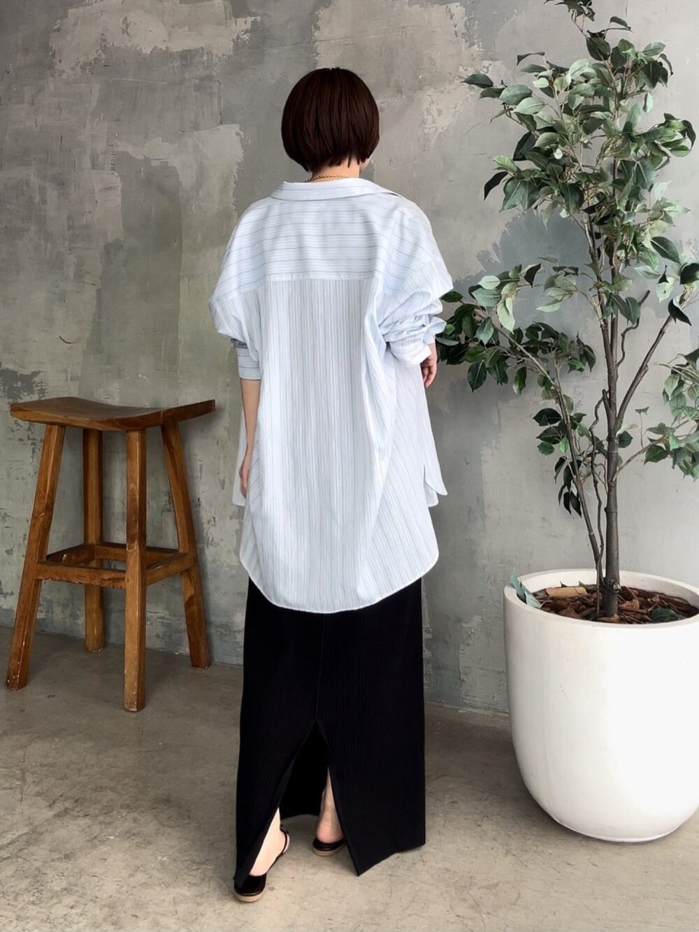 ブラック系のワンピース、ブラック系のサンダル、ブルー系のシャツ/ブラウスを着用したレディースの春コーディネートの3枚目の写真