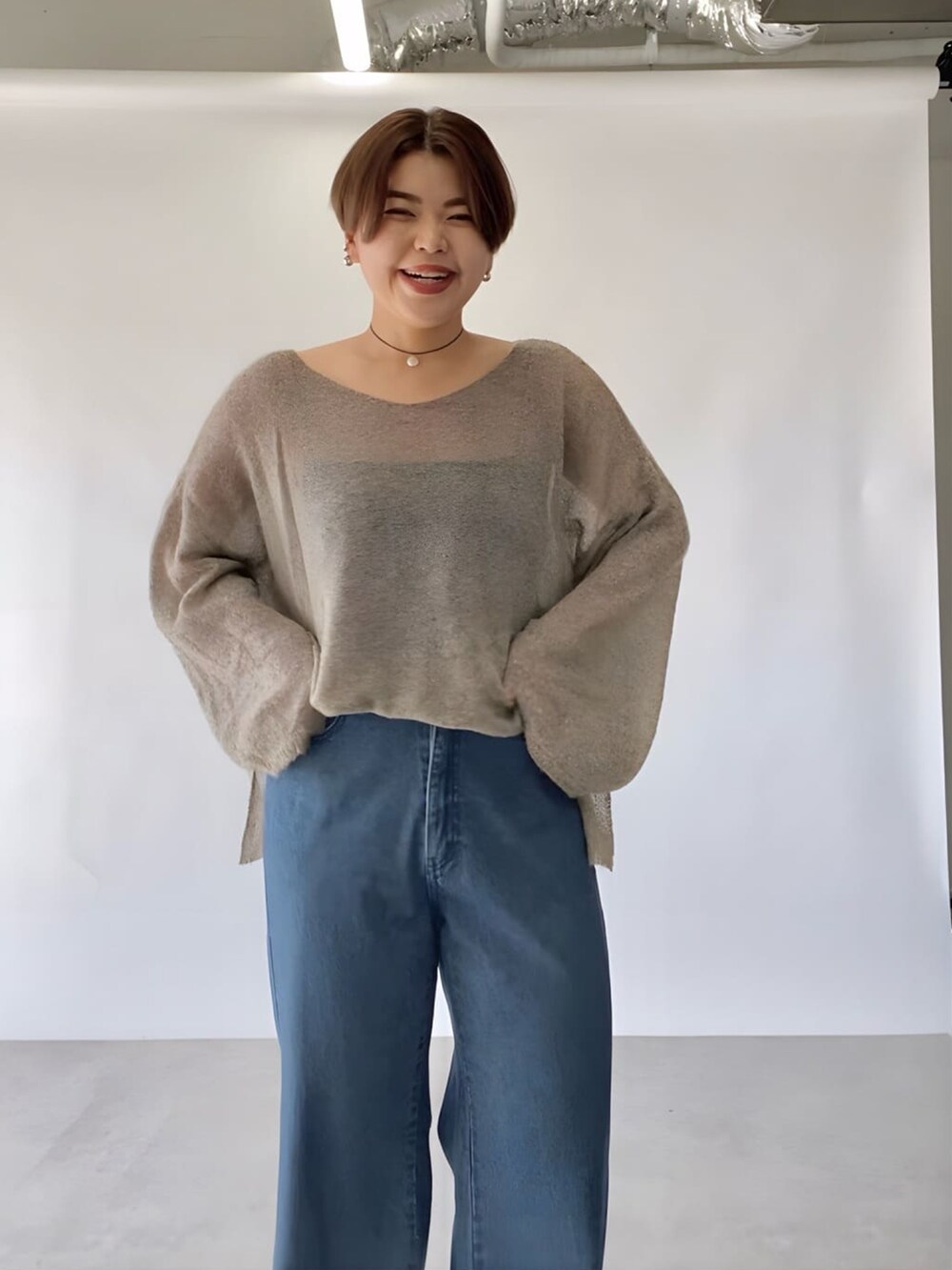 ブラウン系のニット/セーター、ブルー系のデニムパンツ、ブラック系のネックレスを着用したレディースの秋コーディネートの4枚目の写真