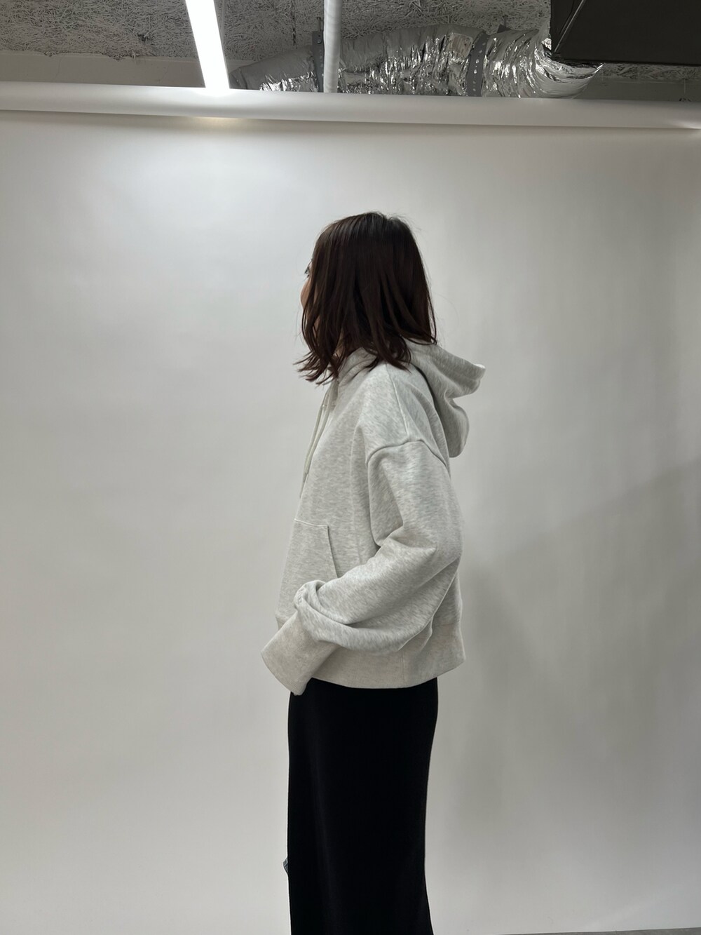 ブルー系のハンドバッグ、ブラック系のスカート、グレー系のパーカーを着用したレディースの冬コーディネートの3枚目の写真