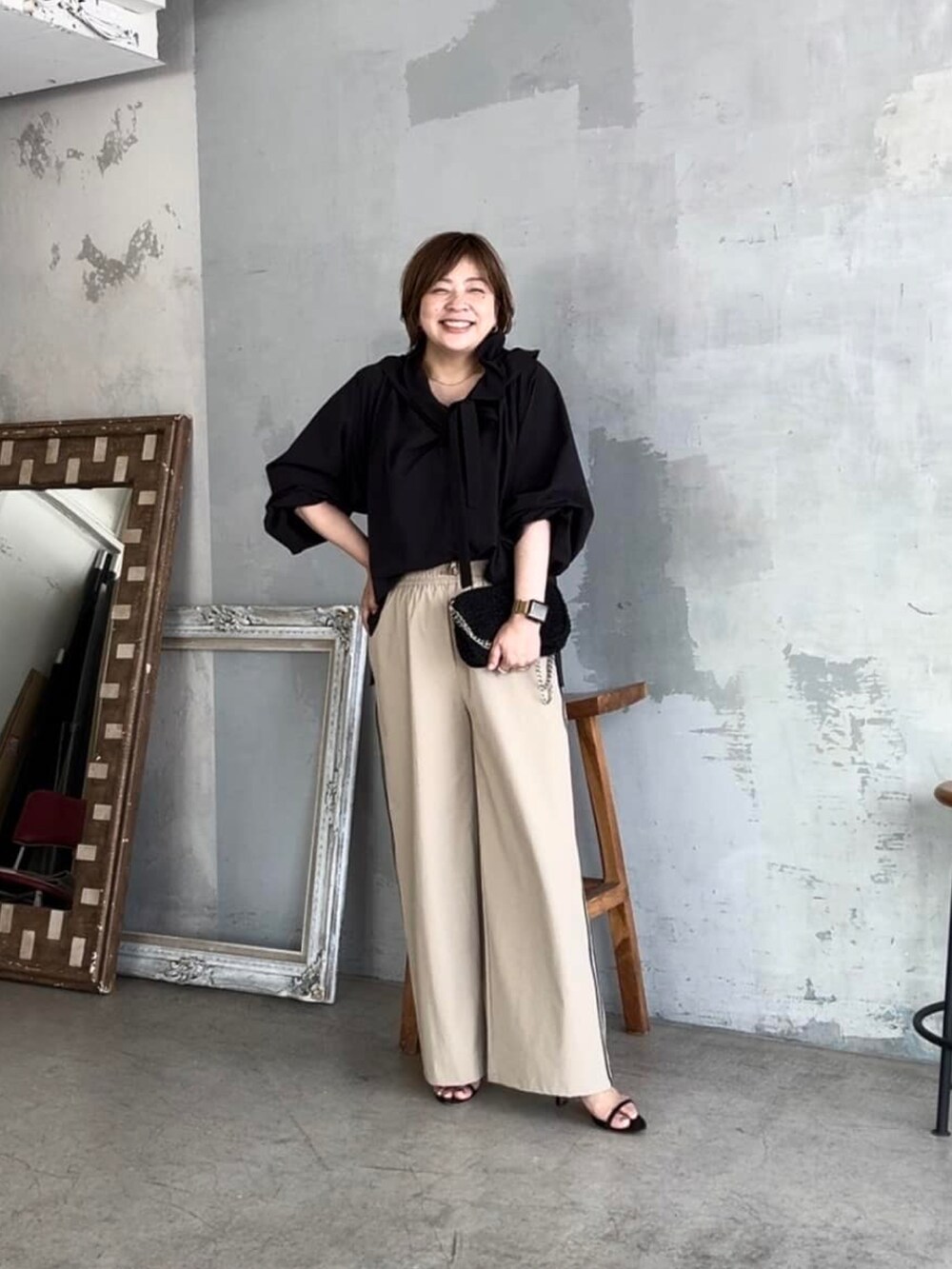 ブラック系のシャツ/ブラウス、ブラック系のショルダーバッグ、ベージュ系のその他パンツを着用したレディースの夏コーディネートの2枚目の写真