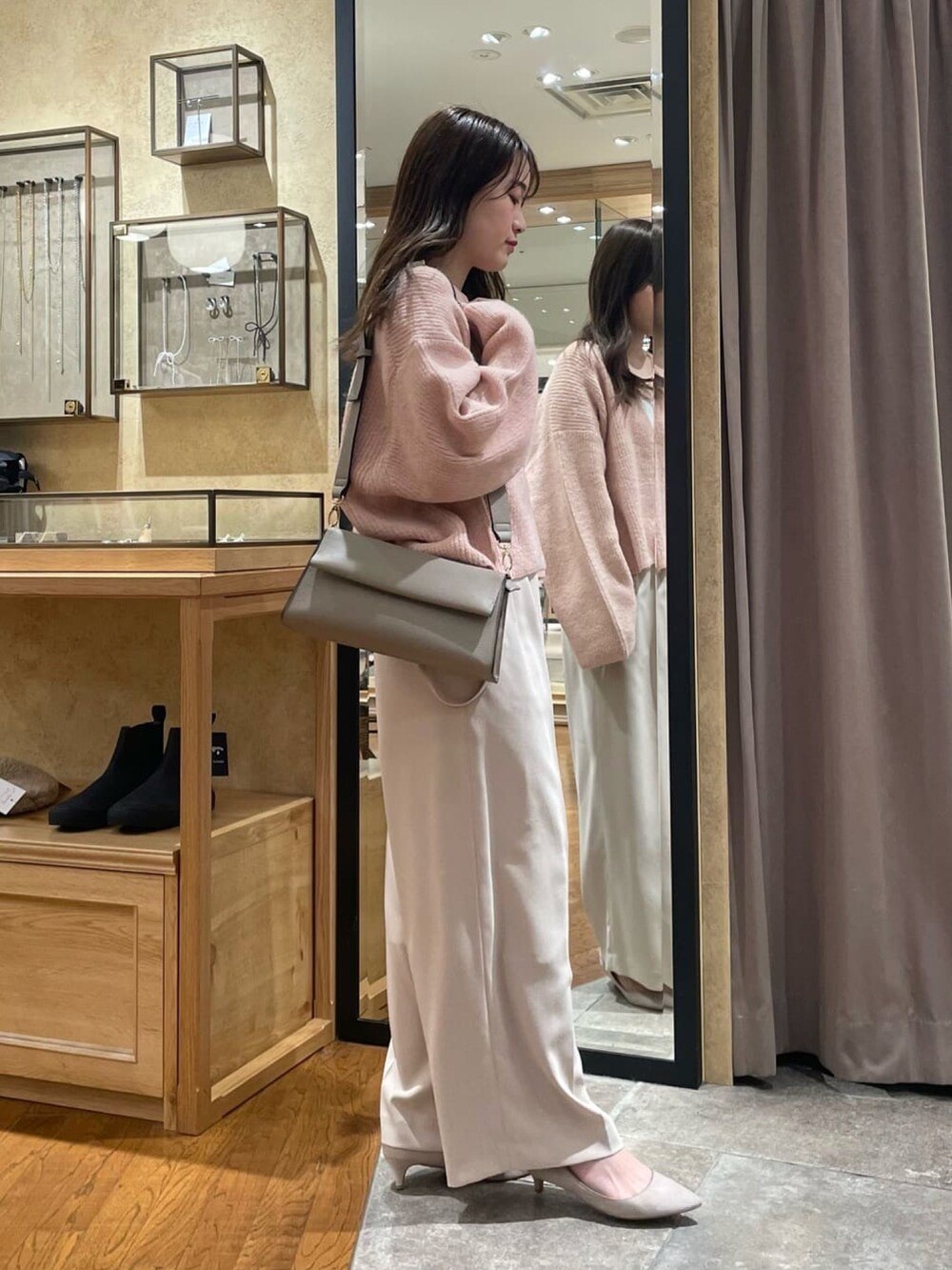 ピンク系のニット/セーター、グレー系のスラックスを着用したレディースの冬コーディネートの2枚目の写真