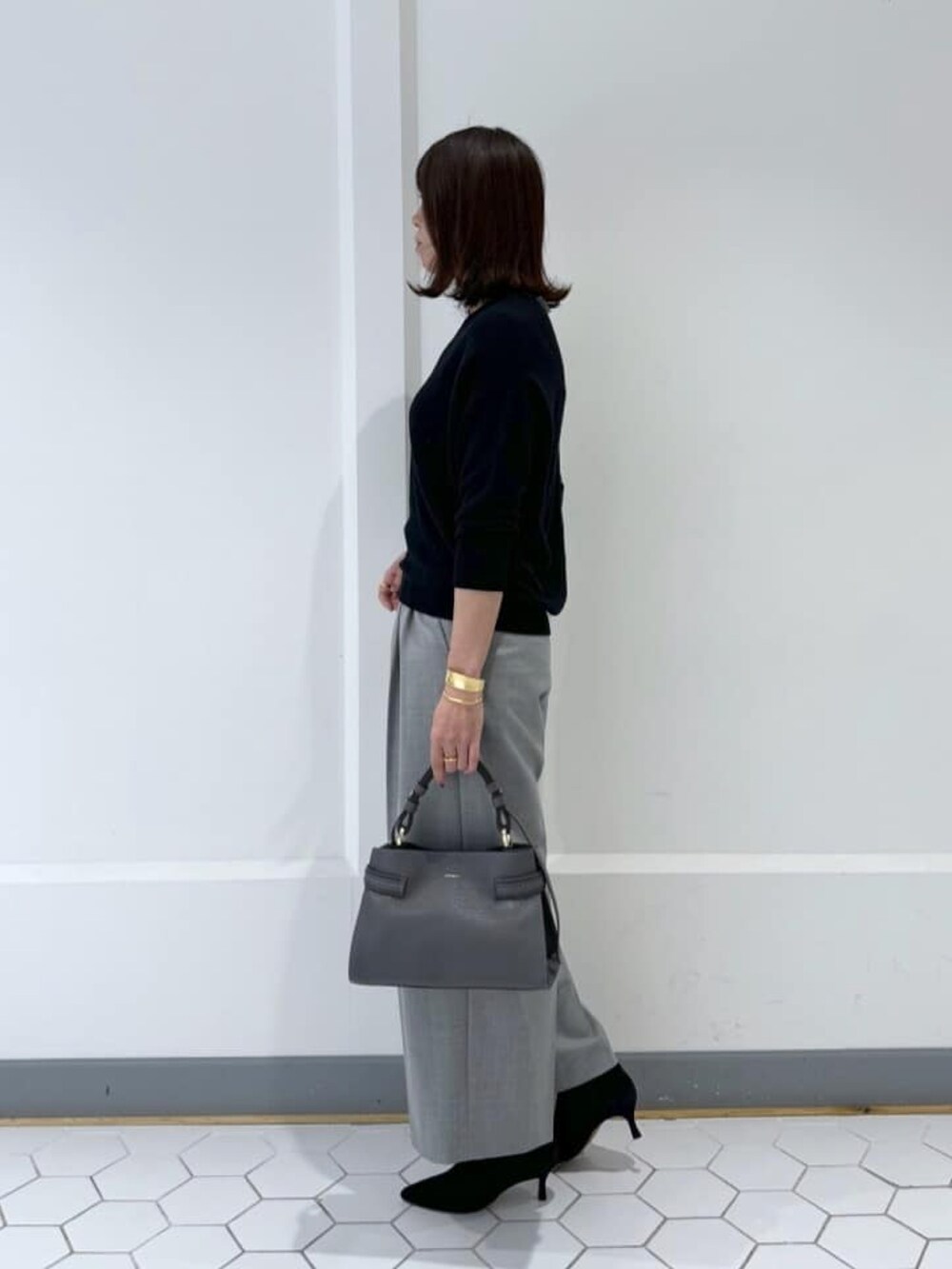 ブラック系のニット/セーター、グレー系のその他パンツ、ブラック系のブーツを着用したレディースの冬コーディネートの2枚目の写真